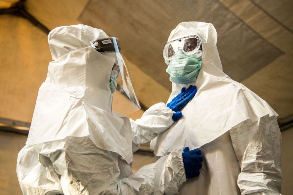 Medical staff check each other's protective suits before entering the isolation unit at a hospital in Bundibugyo, western Uganda, during a suspected case of Ebola. Aug. 17. (Sumy Sadurni /AFP/Getty Images)